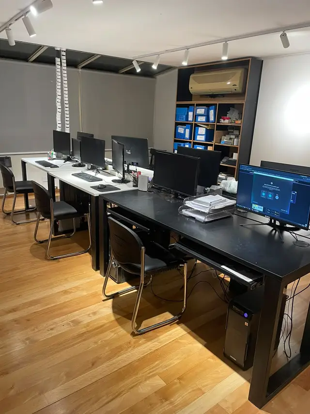 Oficina con escritorios, monitores y computadoras instalados y conectados