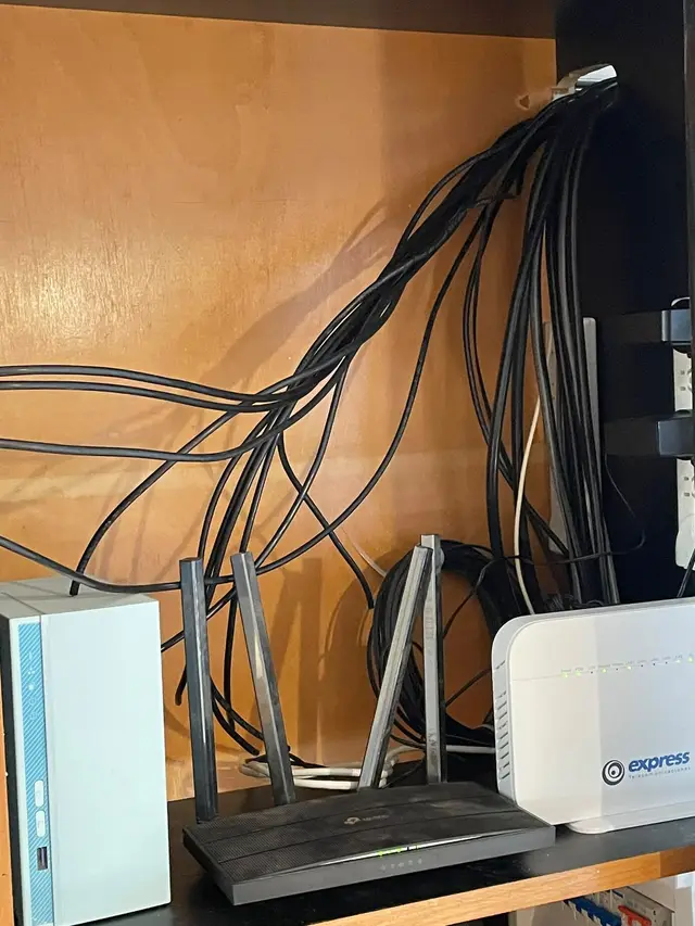 Router, módem y almacenamiento NAS con el cableado organizado en un mueble